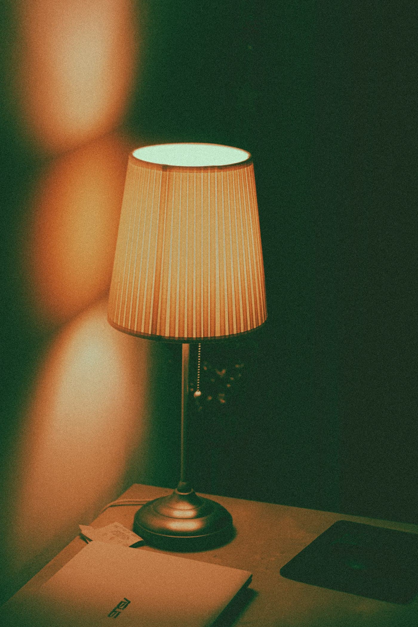A lamp lighting a still, quiet desk — the kind of room you'd read a letter in.
